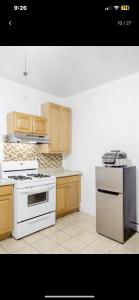 a kitchen with white appliances and wooden cabinets at SUITE Dreams CARROLL 11 in Paterson