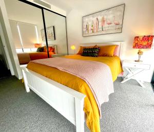 1 dormitorio con 1 cama grande y espejo en Ollies Place en Gold Coast