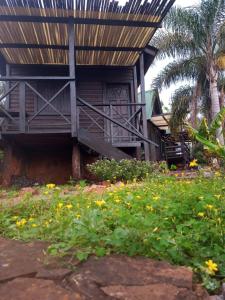 a building with a porch and a bunch of flowers at Cabañas Misioneras in San Ignacio