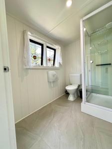 a bathroom with a toilet and a window at Kioloa Beach Cabins in Kioloa