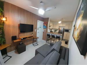 uma sala de estar com um sofá e uma cozinha em Pe na areia Flat Unita 177 na Praia Grande