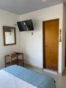 1 dormitorio con 1 cama y puerta de madera en Casa Inés Tolú, en Tolú