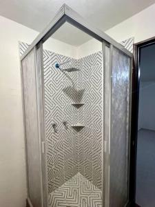a glass shower in a room with a wall at Departamento Doña Maryy in Tampico