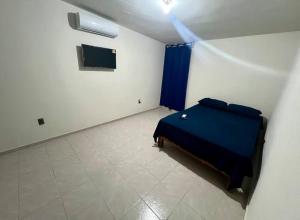 ein Schlafzimmer mit einem blauen Bett in einem Zimmer in der Unterkunft Departamento Doña Maryy in Tampico