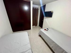 Kleines Zimmer mit einem Bett und einer Tür in der Unterkunft Departamento Doña Maryy in Tampico