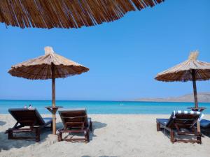 2 Stühle und Sonnenschirme am Strand mit Meerblick in der Unterkunft Luxurious 6 bedroom villa In a great location in Chalkida