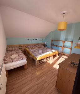オシュチュニツァにあるDvojizbový Útulný Apartmán Oščadnicaのベッドルーム1室(ベッド2台、テーブル付)