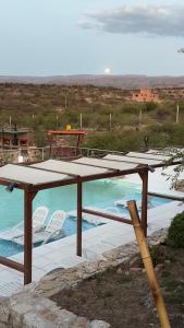 una mesa de picnic y sillas junto a una piscina en Valle Las Piedras en Arroyo de Los Patos