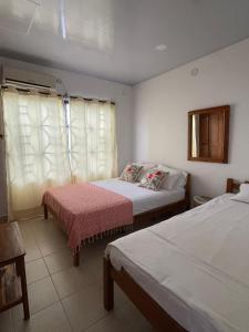 Habitación de hotel con 2 camas y ventana en Casa Inés Tolú en Tolú