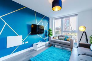 uma sala de estar azul com um sofá e uma televisão em Spacious 3-Bedroom Apartment in Central Manchester with Private Rooftop Terrace & Stunning City Views em Manchester