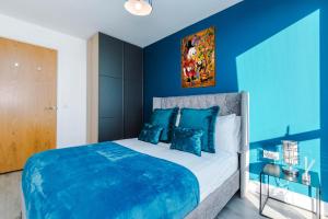 um quarto azul com uma cama grande e paredes azuis em Spacious 3-Bedroom Apartment in Central Manchester with Private Rooftop Terrace & Stunning City Views em Manchester