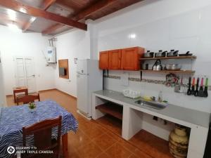 una cucina con lavandino, frigorifero e tavolo di La Mulata Apart a Puerto Iguazú