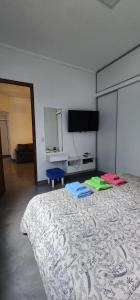 um quarto com uma cama e uma televisão de ecrã plano em 9 de julio em San Miguel de Tucumán