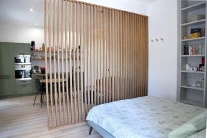Un dormitorio con una partición con una cama y una mesa. en La Casa di Gadu, en Casalnuovo di Napoli