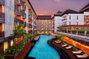 a hotel swimming pool with lounge chairs and a resort at Fairfield by Marriott Bali Kuta Sunset Road in Kuta