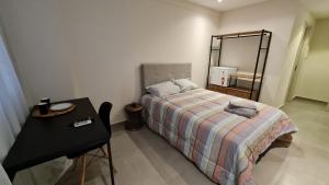 ein Schlafzimmer mit einem Bett und einem Tisch mit Spiegel in der Unterkunft Flat encantador América Campos in Campos dos Goytacazes + 35 Fotos