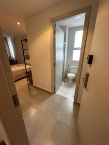 ein Badezimmer mit Toilette und ein Zimmer mit einem Bett in der Unterkunft Flat encantador América Campos in Campos dos Goytacazes