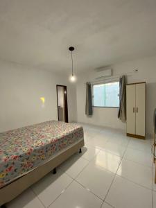 a bedroom with a bed and a window at Casa Arembepe in Camaçari