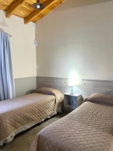 1 dormitorio con 2 camas y una lámpara en una mesa en Cabañas Mágico Atardecer en San Rafael