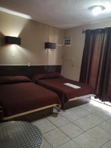 a hotel room with two beds and a window at Hotel Costa Miramar Acapulco in Acapulco