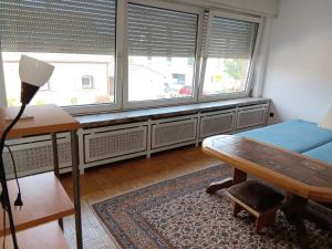 een kamer met een bureau, een bed en ramen bij AH G3 OG in Schwalmtal