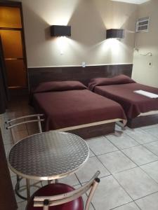 um quarto com duas camas e uma mesa e uma mesa e cadeiras em Hotel Costa Miramar Acapulco em Acapulco