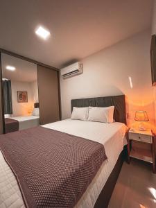 a bedroom with a large bed and a bathroom at Apartamento em Vila Velha na quadra do Mar. in Vila Velha