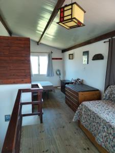 a bedroom with a bed and a desk and a table at Casa Nuestro Sueño in Punta Del Diablo