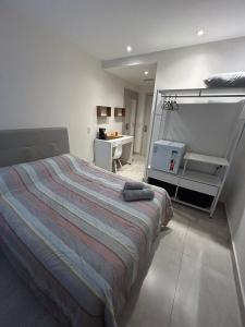 a bedroom with a bed and a desk in it at Flat América Campos Pelinca in Campos dos Goytacazes