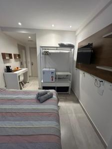 1 dormitorio con cama, escritorio y mesa en Flat América Campos Pelinca en Campos dos Goytacazes