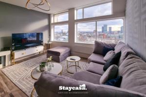 a living room with a couch and a tv at Luxury 2bdr Penthouse On 23rd Floor With View in Manchester