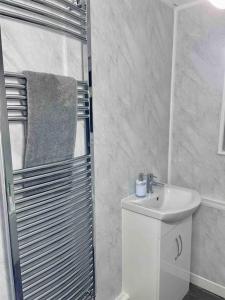 a white bathroom with a sink and a shower at Home In Medway in Chatham