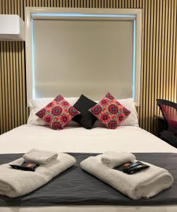 ein Bett mit Handtüchern und Kissen darüber in der Unterkunft Comfort Inn Serenity Bathurst in Bathurst