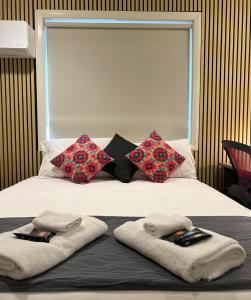 Una cama con toallas y almohadas encima. en Comfort Inn Serenity Bathurst, en Bathurst