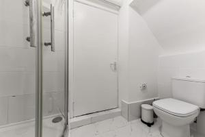 a white bathroom with a toilet and a shower at Deluxe Studio Near Camden Town in London