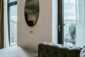 einen Spiegel an der Wand in einem Zimmer mit Sofa in der Unterkunft Highgarden Hotel in Tbilisi City