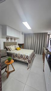 a bedroom with a bed and a couch at Studio Barra Premium in Salvador