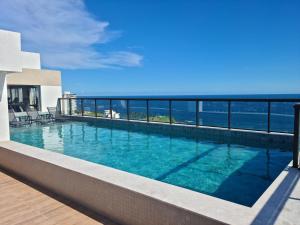 a swimming pool with a view of the ocean at Studio Barra Premium in Salvador