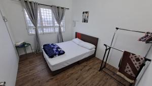 1 dormitorio pequeño con 1 cama y 2 ventanas en 1201 Apartment Ladang Tok Pelam TepiPantaiBatuBuruk, en Kuala Terengganu