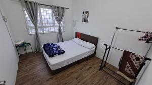 a small bedroom with a bed and two windows at 1201 Apartment Ladang Tok Pelam TepiPantaiBatuBuruk in Kuala Terengganu