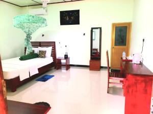a bedroom with a bed and a desk and a mirror at Panoramic Royal Villa in Sigiriya