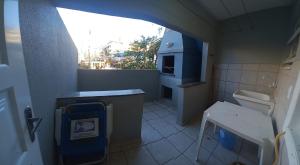 a small bathroom with a sink and a stove at Edificio Daniela Ap 101 in Bombinhas