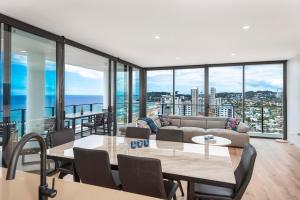 uma sala de estar com um sofá e uma mesa em Breathtaking Burleigh Beach Abode em Gold Coast