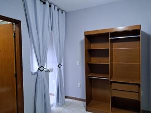 um quarto com uma cortina e um armário em Casa aconchego Parque Mambucaba em Angra dos Reis