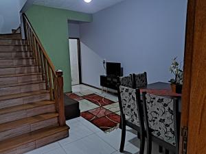 a living room with stairs and a table and chairs at Casa aconchego Parque Mambucaba in Angra dos Reis