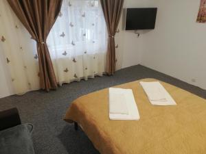 a room with a bed with two white towels on it at Casa Bucur in Tîrgu Ocna