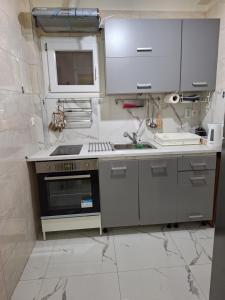 a kitchen with a sink and a stove at Comfortable near metro by hospitality gr in Athens