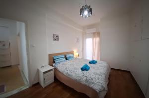 a bedroom with a bed with two blue pillows at Comfortable near metro by hospitality gr in Athens