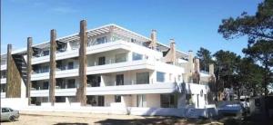 a large white building with aventh floor at depto pinamar in Pinamar