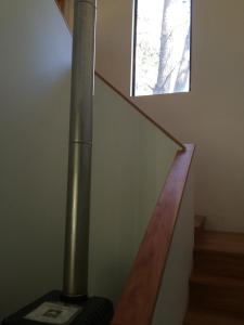 eine Treppe mit einer Metallstange und einem Fenster in der Unterkunft House & Lake rapel in Las Cabras